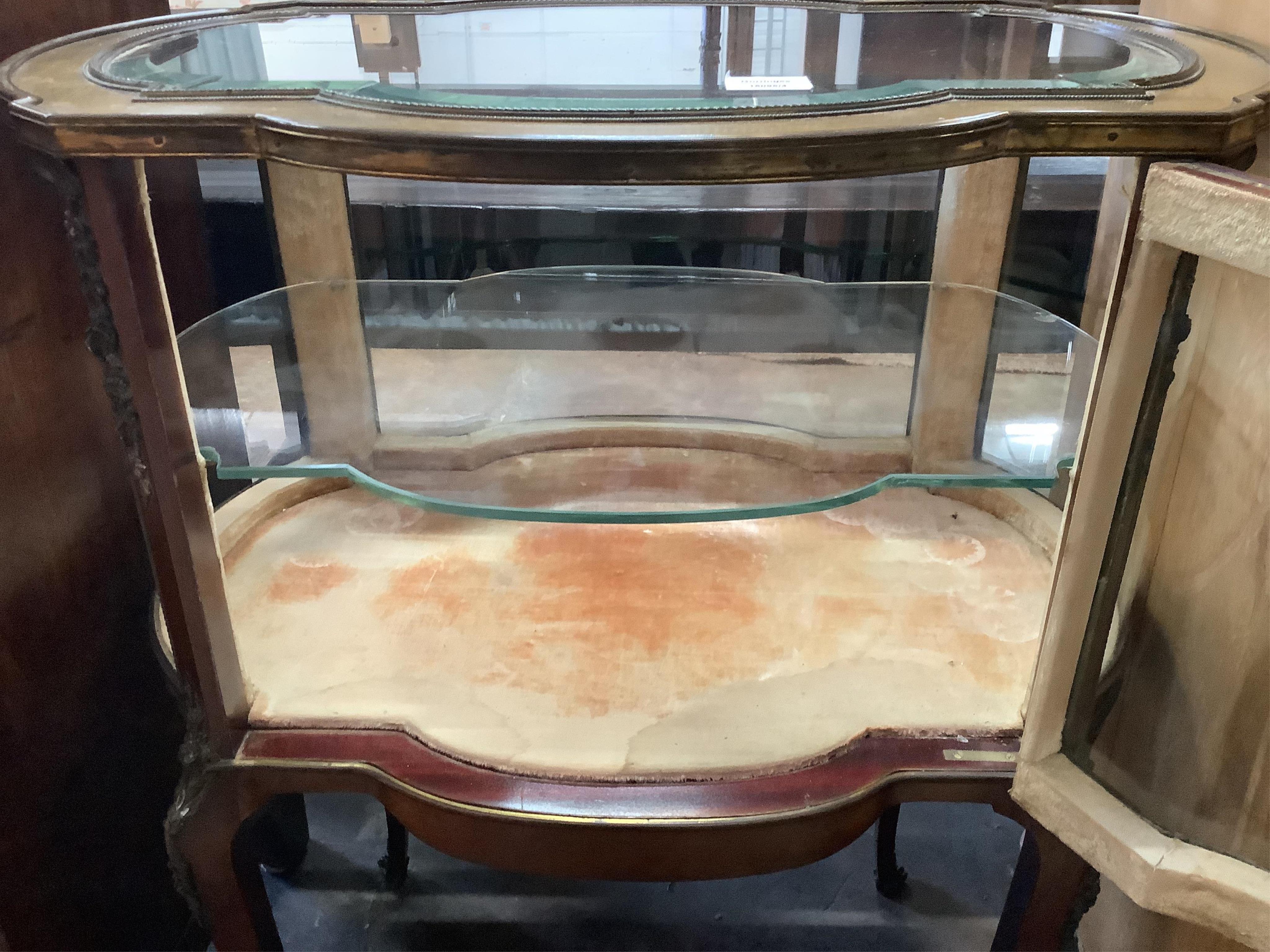 An early 20th century gilt metal mounted mahogany bijouterie cabinet, (one glass panel missing), width 68cm, depth 46cm, height 86cm. Condition - fair